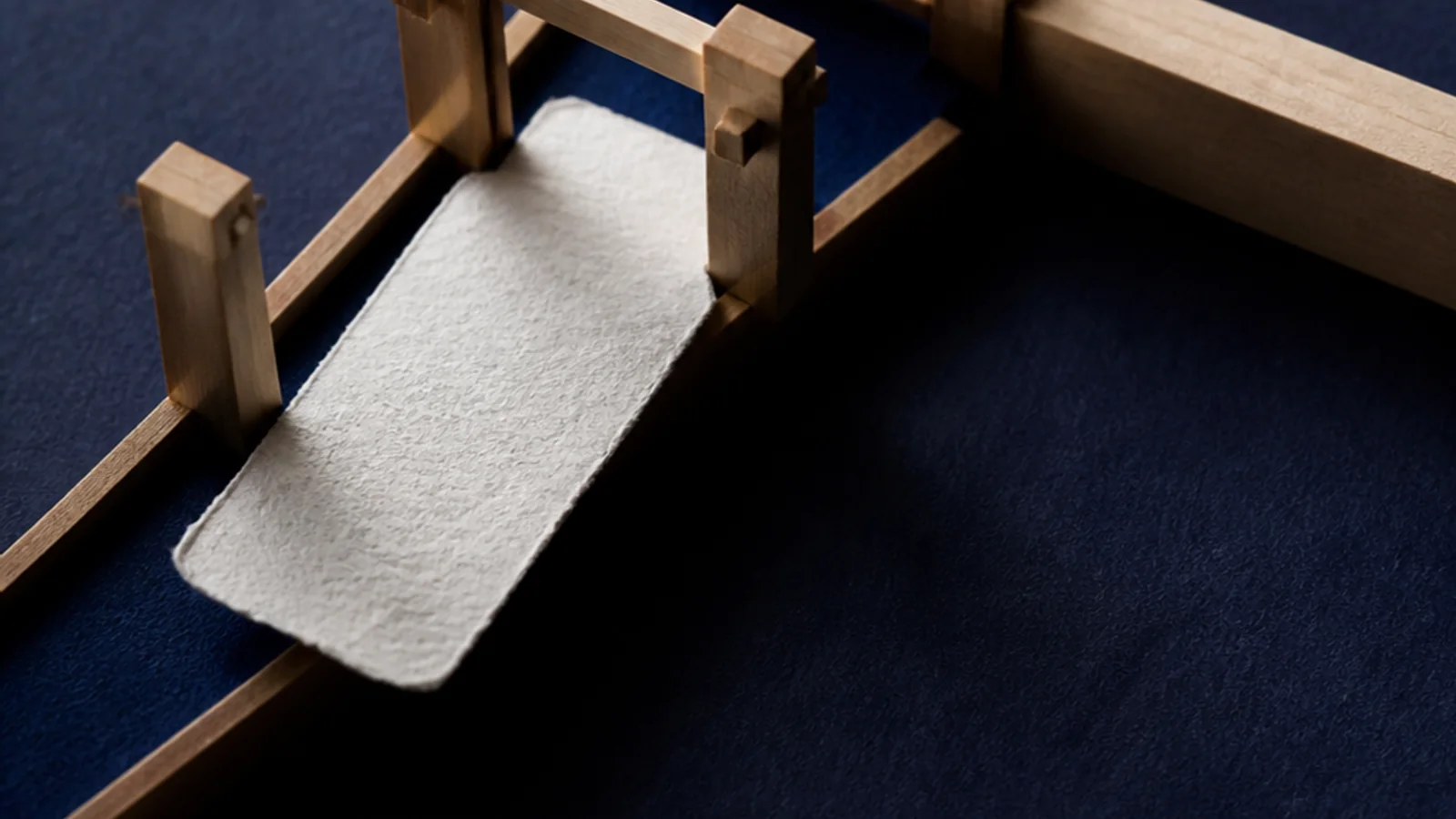 A washi commission card enters an indigo clockwork path, passes receipt and inspection gates, and reaches a cobalt payment marker.