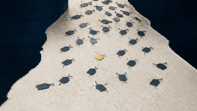 A pale paper tide carrying many small indigo luggage tags through a narrow gate of light.