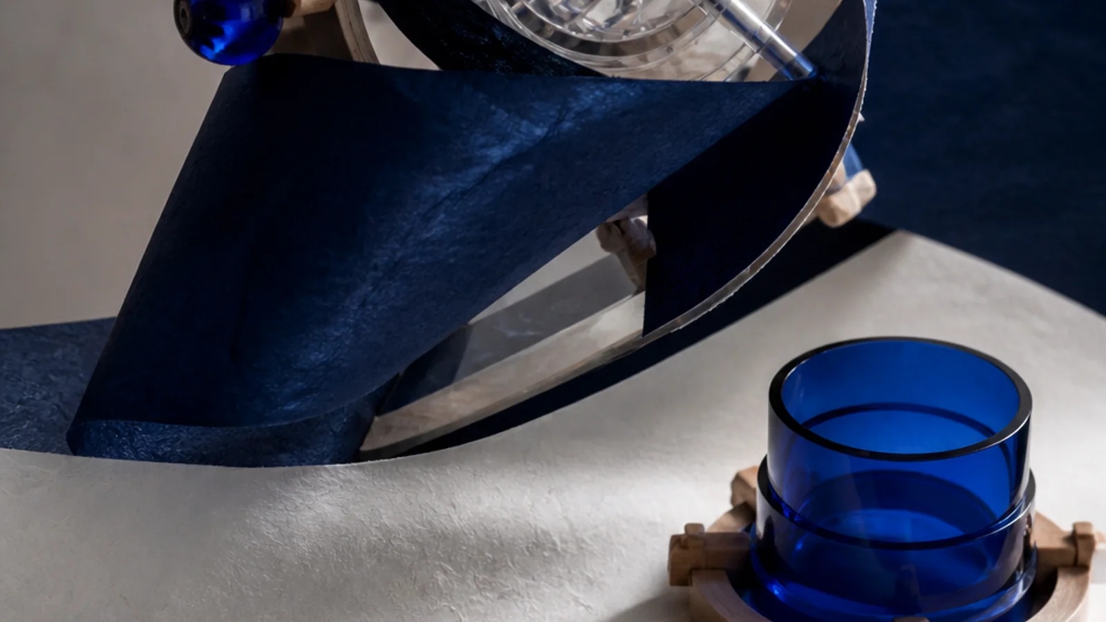 An evolving indigo plan scroll orbits a transparent AI mechanism while a separate cobalt product gate remains unstamped.